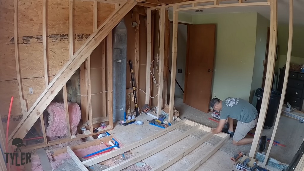 man constructing frame for shower wall
