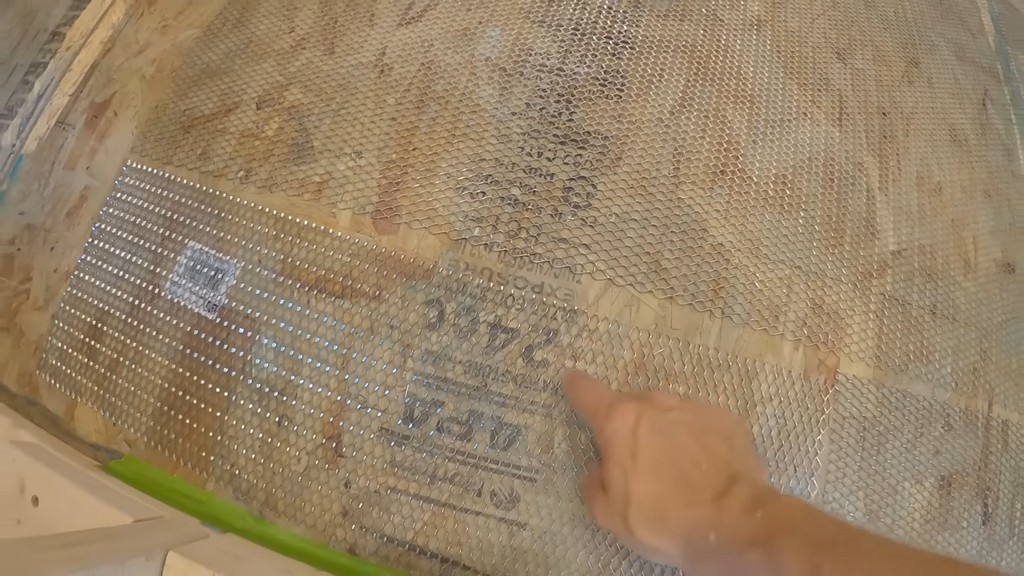 man gesturing to bathroom mesh on OSB subflooring