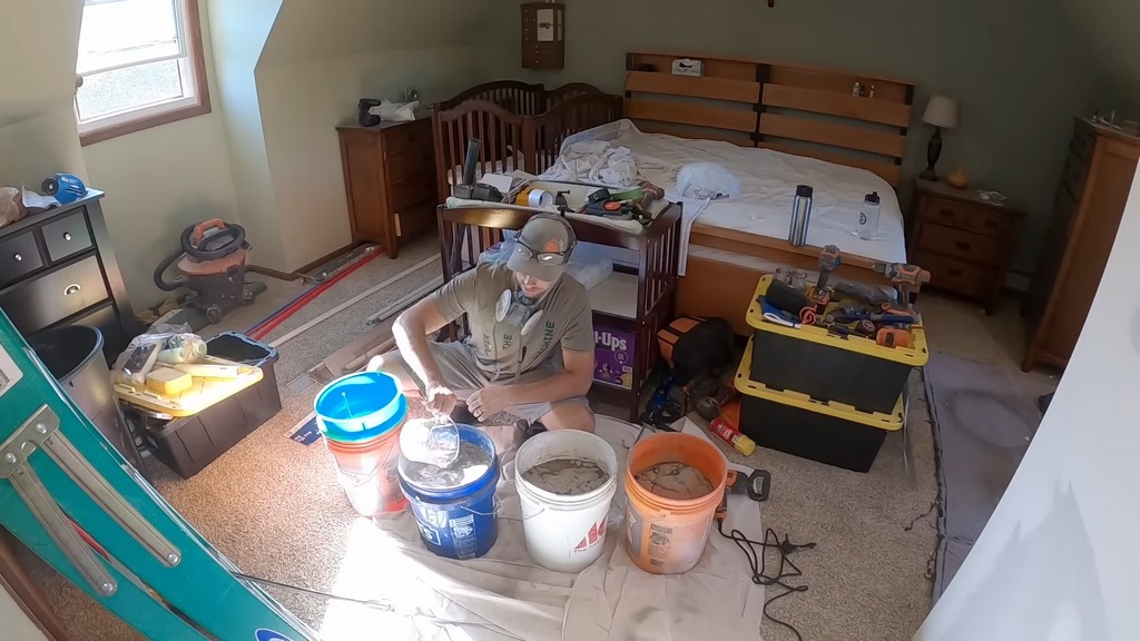 man pouring water into self-leveling compound mix for OSB floors