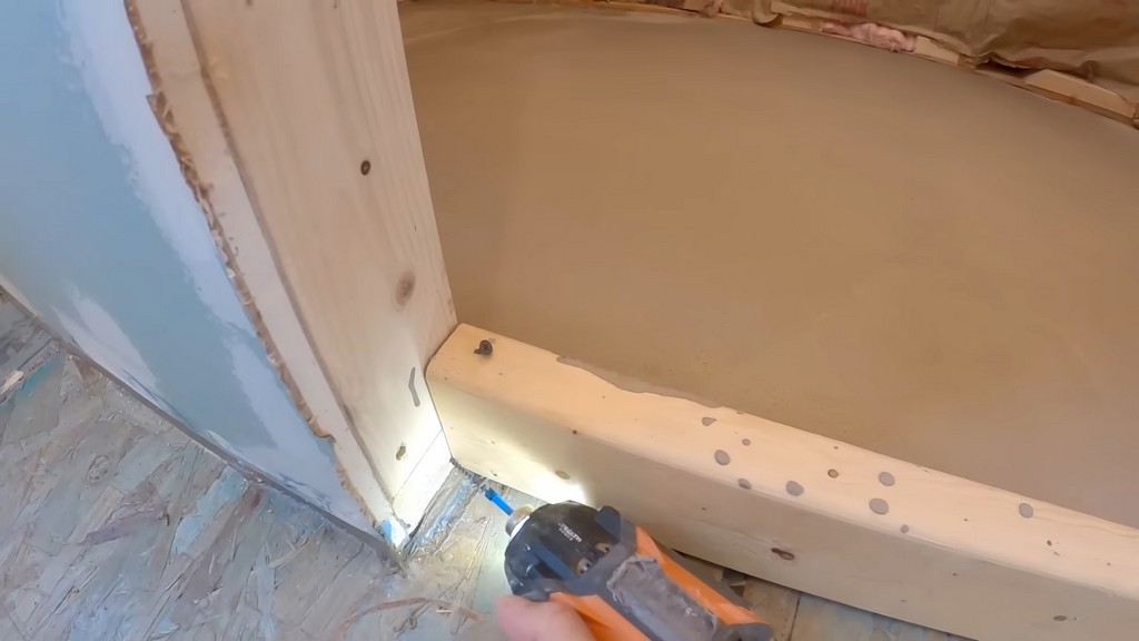 man removing screws from board with drill driver