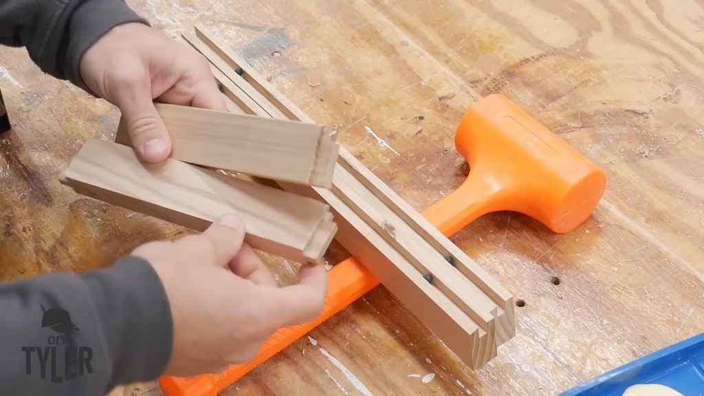 man inserting ball spacers into grooves of pieces for DIY functional bathroom shelf