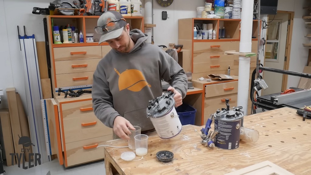 man pouring wood finish from mixing can