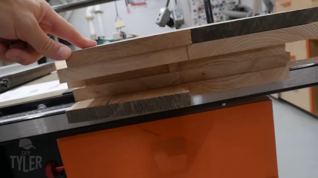 man pointing to stack of planed ash wood boards for diy functional bathroom shelf