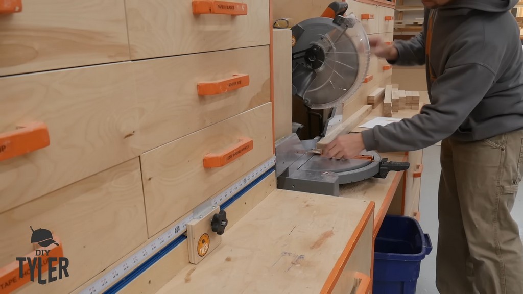 man cutting board pieces with miter saw