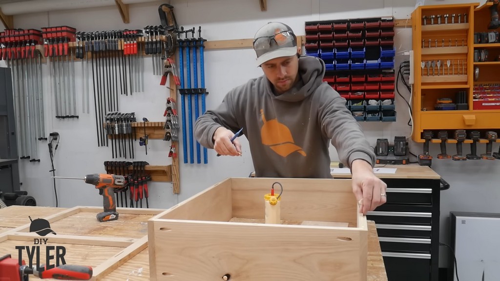 man inserting biscuits into box frame for DIY functional bathroom shelf