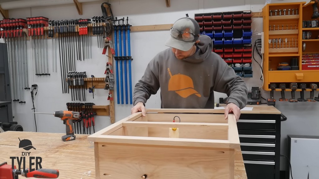 man adding face frame to box frame for DIY functional bathroom shelf