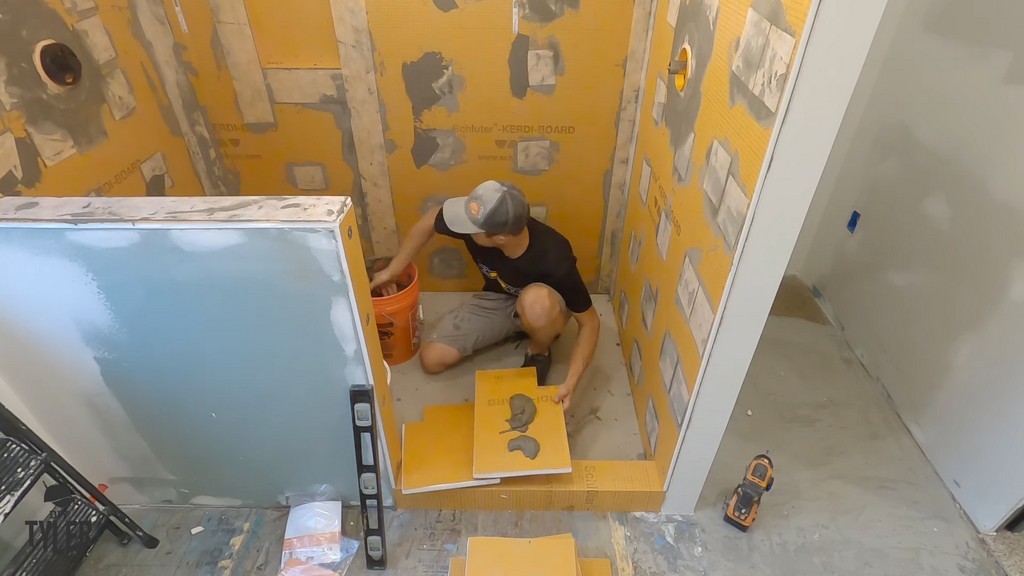 man mudding two boards together for walk-in shower bench