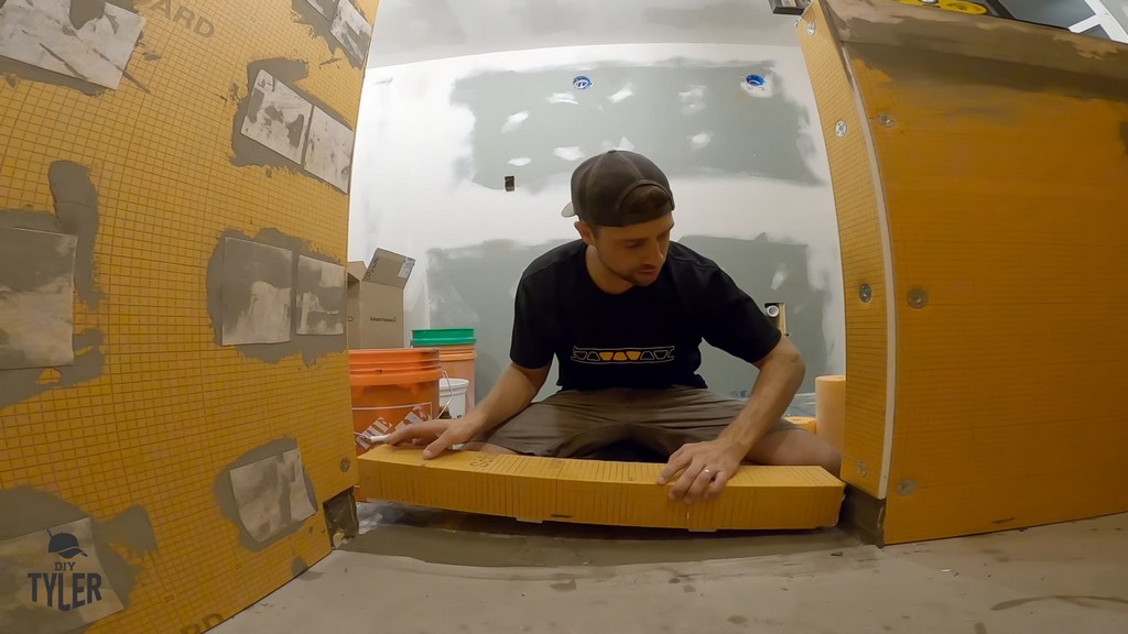 man installing shower curb piece to walk-in shower