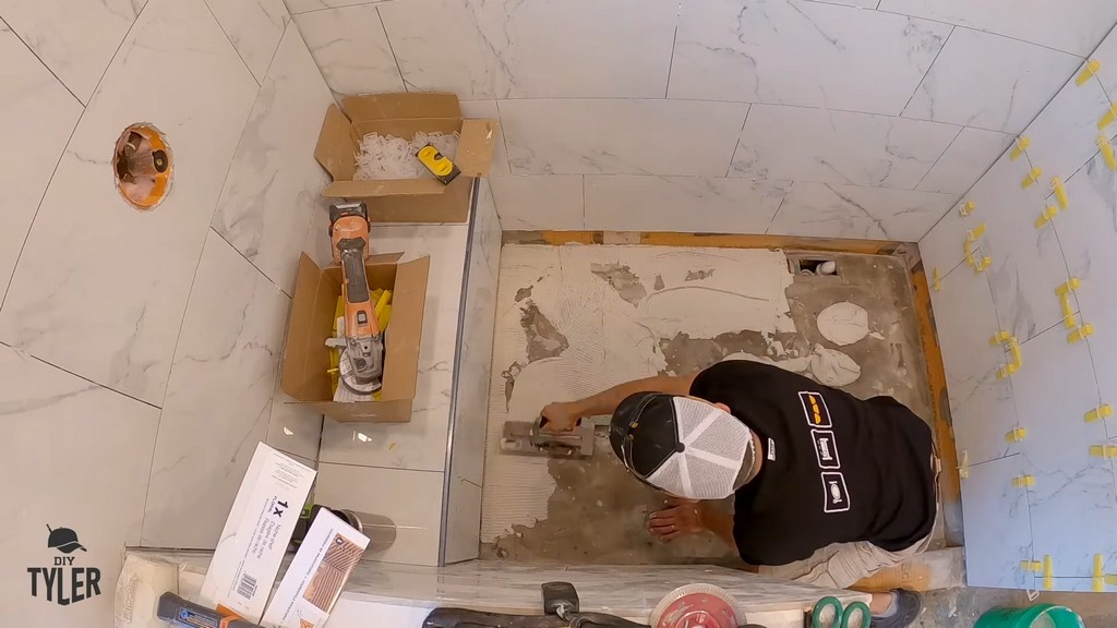 man mudding floor of unfinished walk-in shower for shower pan