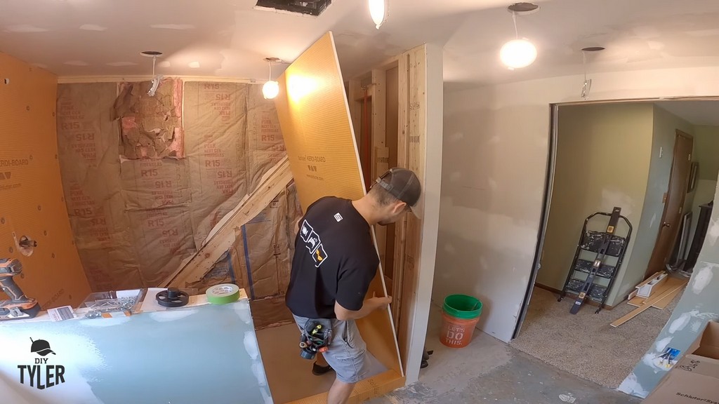 man installing Kerdi board into walk-in shower