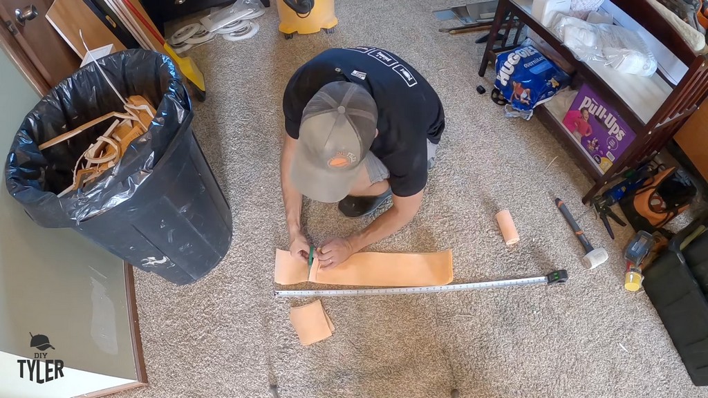 man cutting out 5x5 pieces of Kerdi band