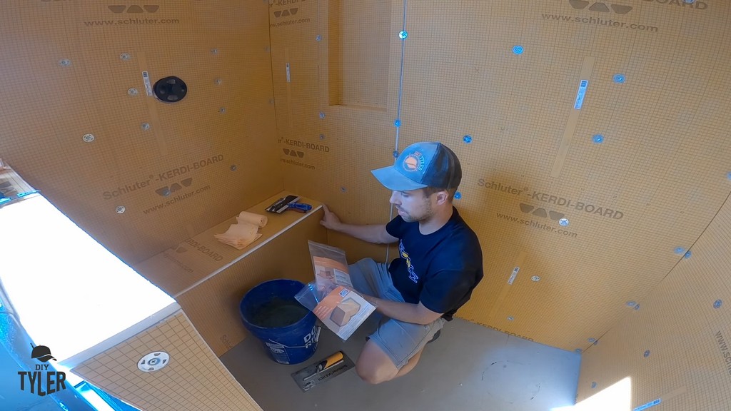 man holding premade inside and outside corner waterproofing pieces