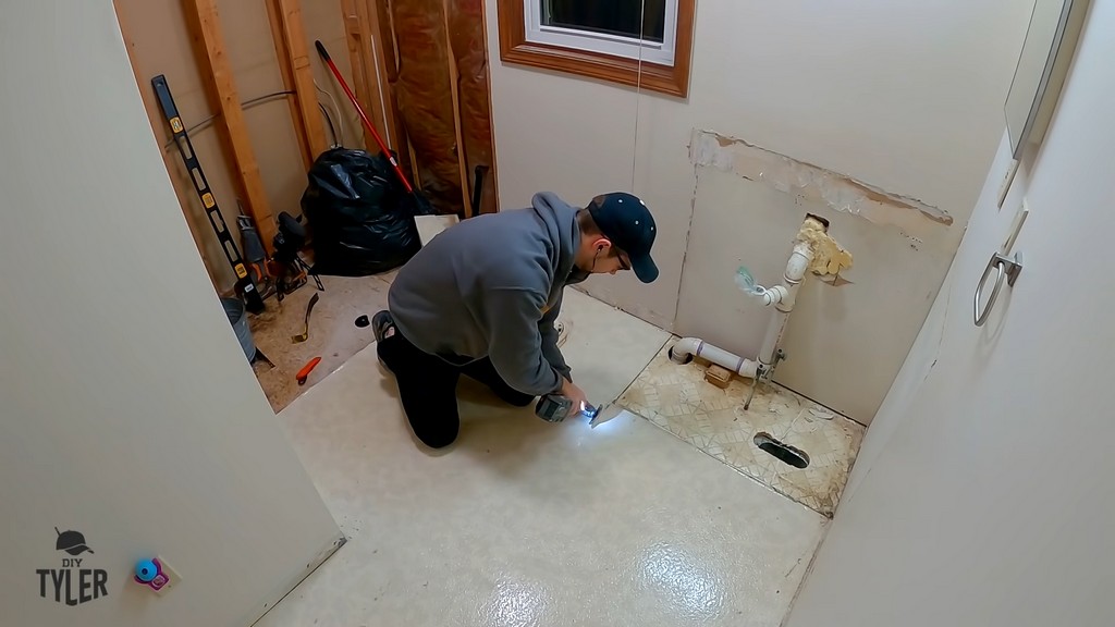 man cutting into one-sheet linoleum flooring with oscillating tool