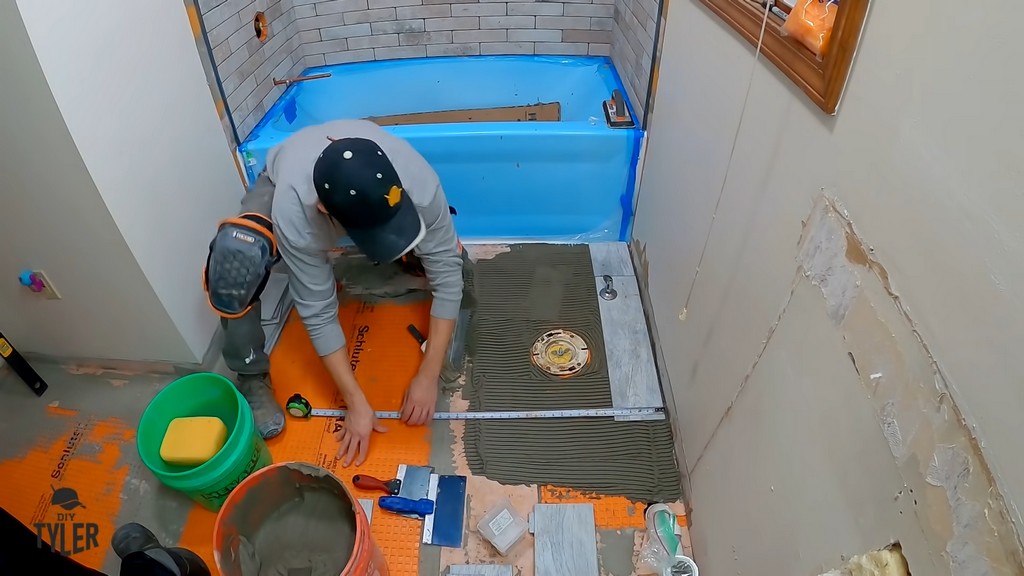 man checking tiling to ensure square