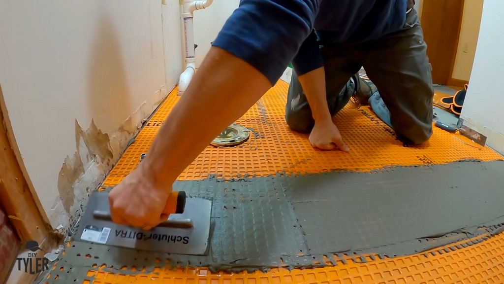 man applying mortar to seams of Schluter DITRA underlayment