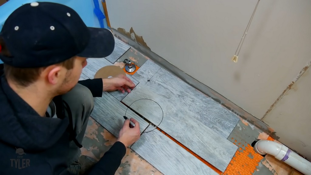 man in front of markings for cutting hole into tiles