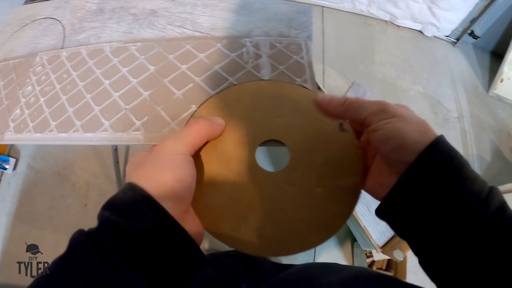 man using cardboard cutout to mark hole on bottom of tile