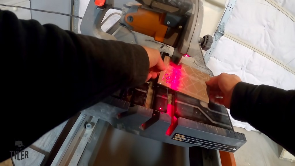 man cutting hole in tile with wet tile saw