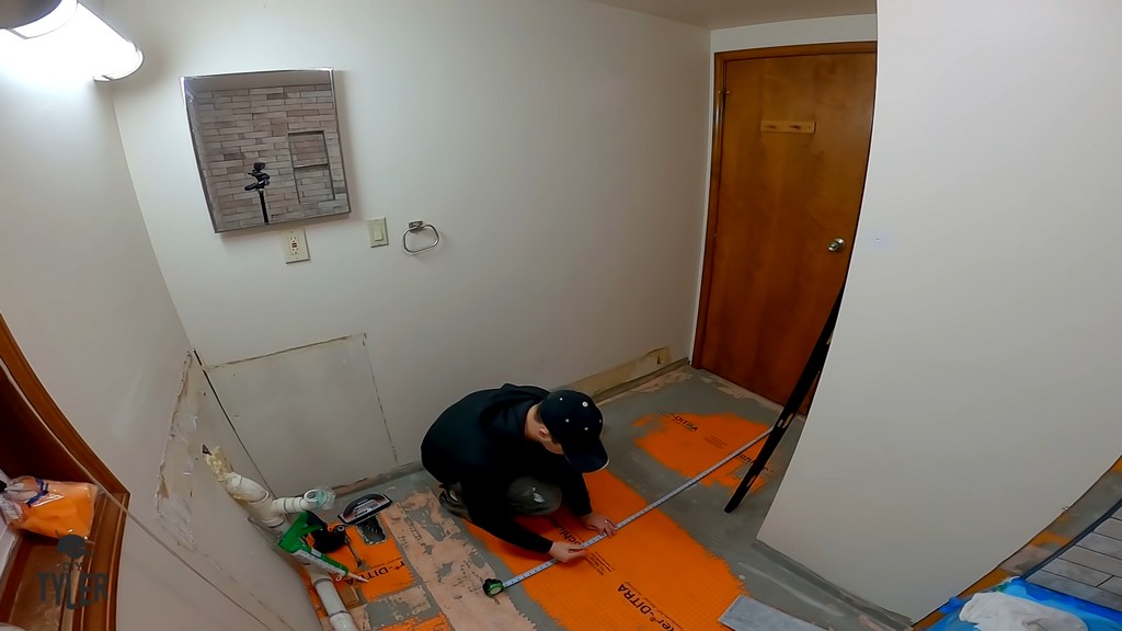 man measuring reference line for tiling in bathroom