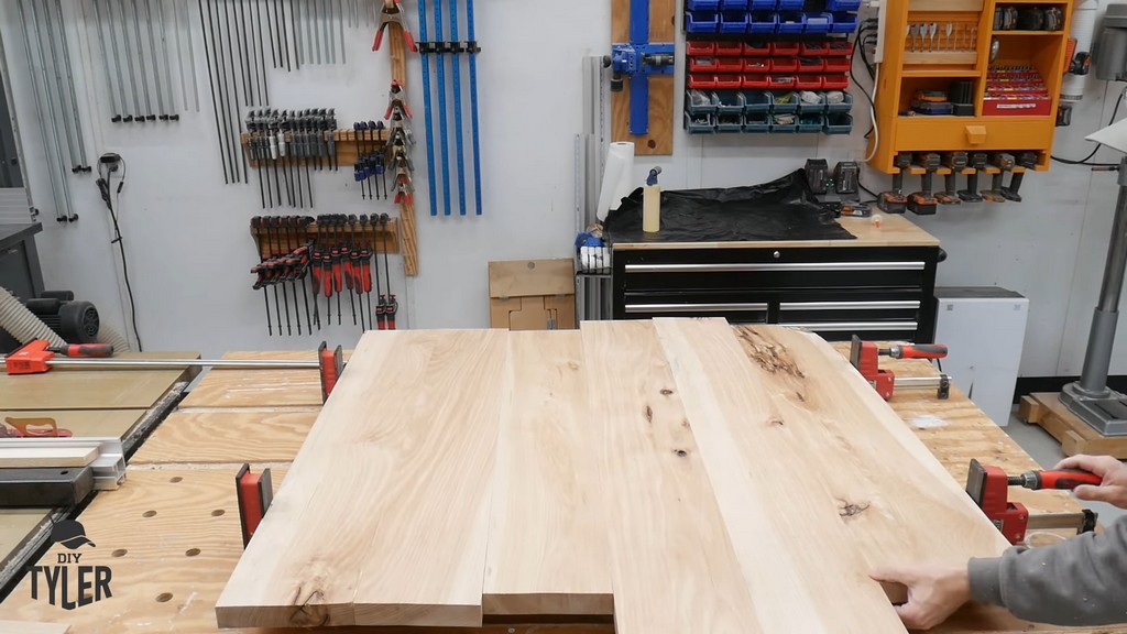 man clamping glued hickory boards together for DIY round coffee table