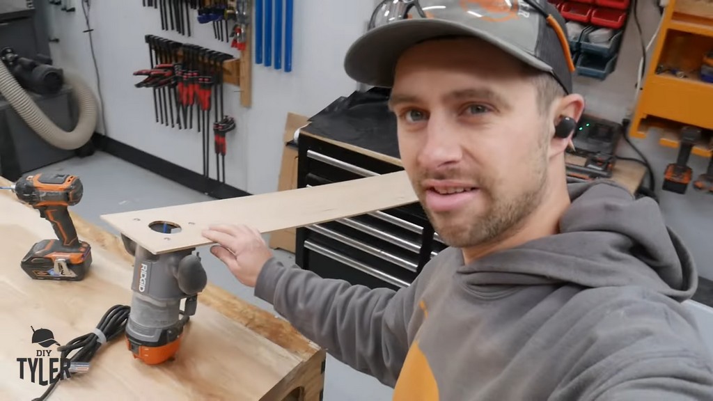 man demonstrating jury-rigged radius jig with router, straight bit, and plywood