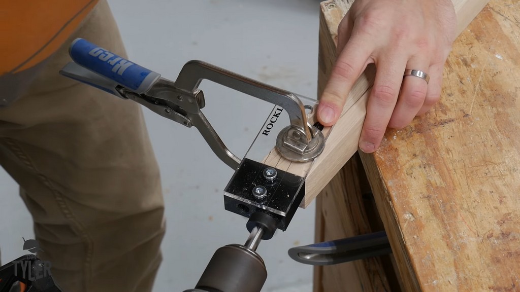 man drilling dowel hole into table leg using Rockler dowel guide jig