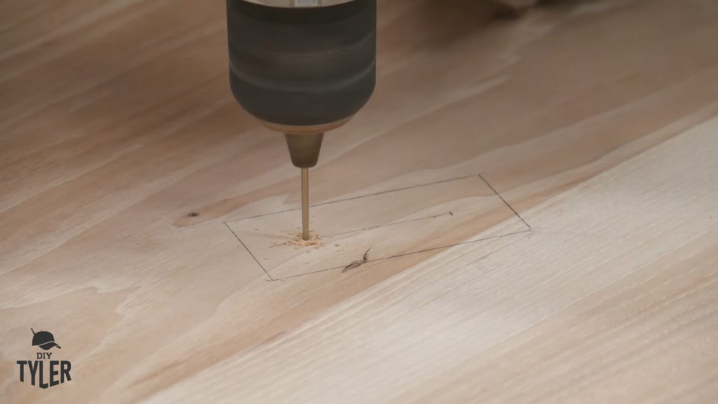 man drilling pilot holes into tabletop for DIY round coffee table