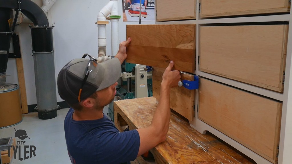 man using additional drawer front piece to check for vertical alignment