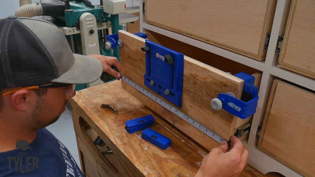 man measuring spacing for Kreg drawer front handle jig
