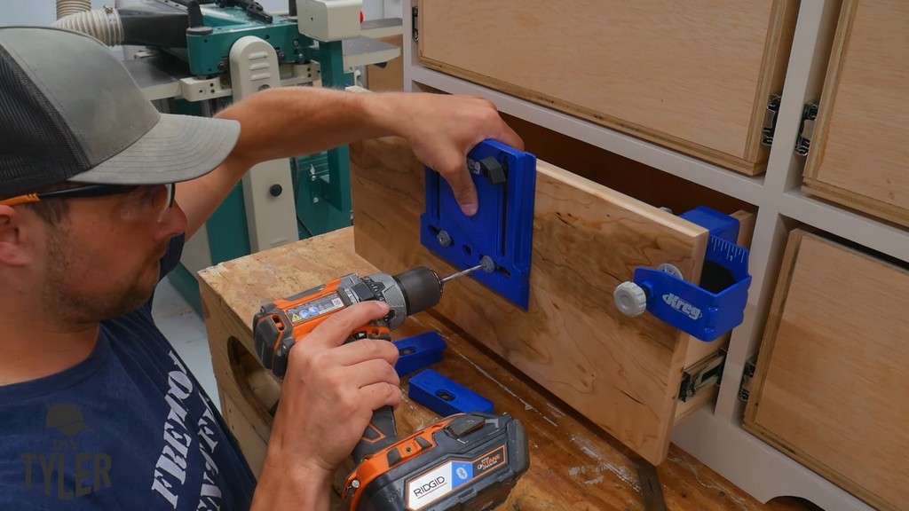 man drilling holes using Kreg drawer front handle jig