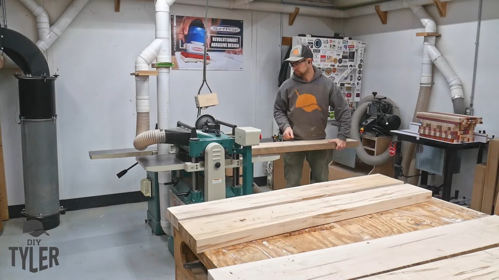 man running piece of maple wood through planer