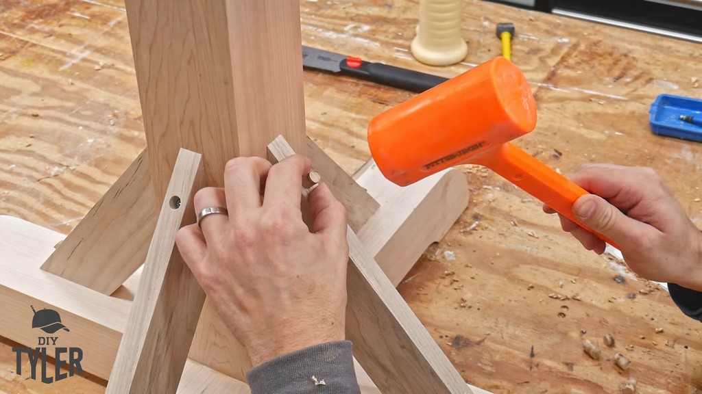 man capping drill hole with maple plug