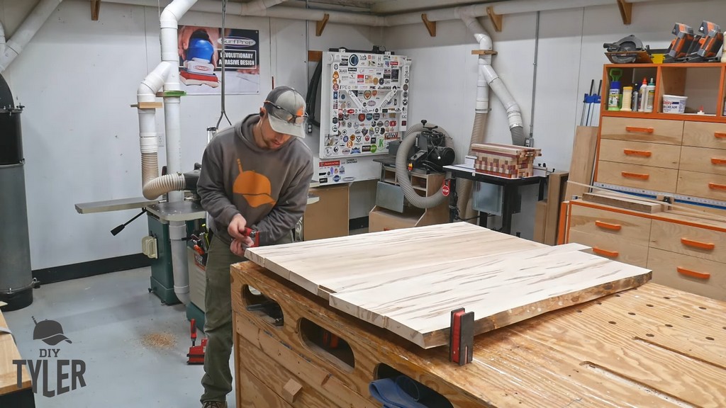 man applying clamps to glued maple wood slab pieces