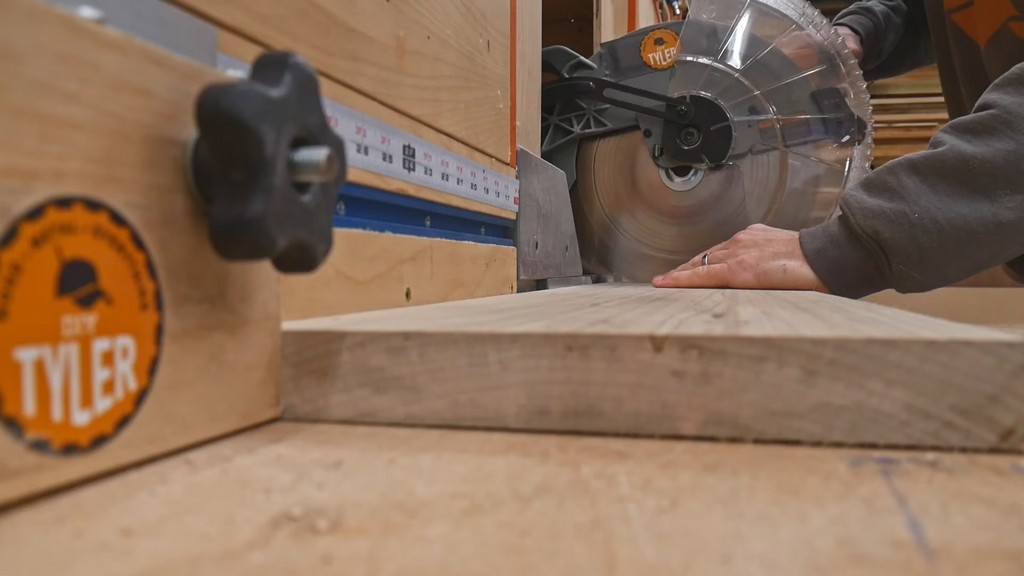 man cutting maple wood piece with miter saw