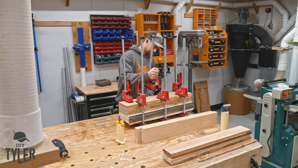 man clamping glued maple wood pieces together