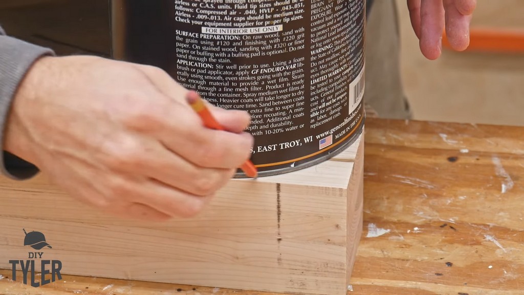man using paint can to mark curves in maple wood piece