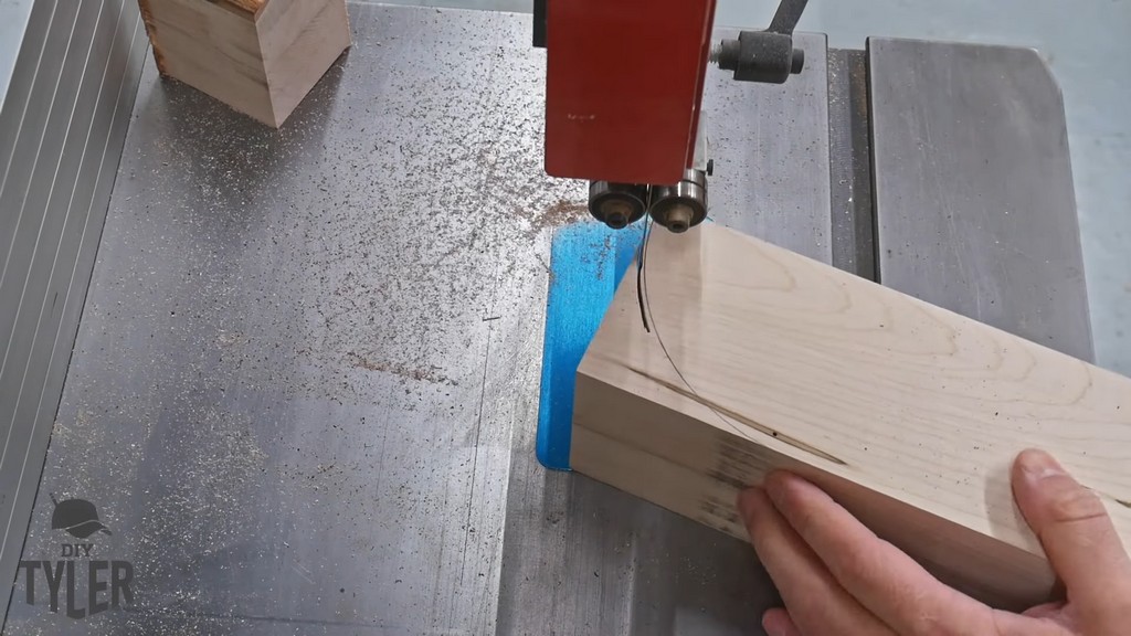 man cutting curved edge with band saw