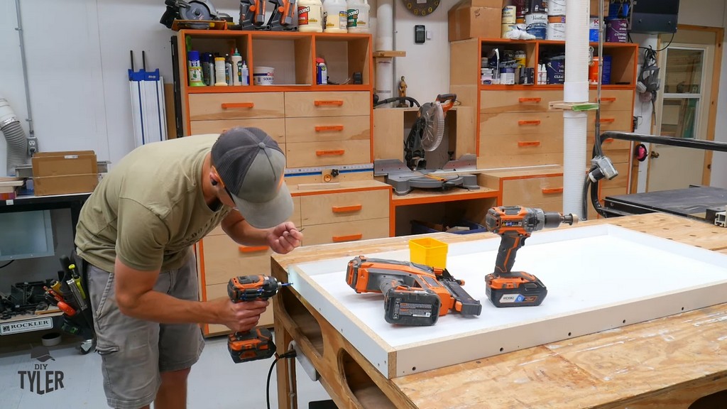 man drilling melamine material into frame shape