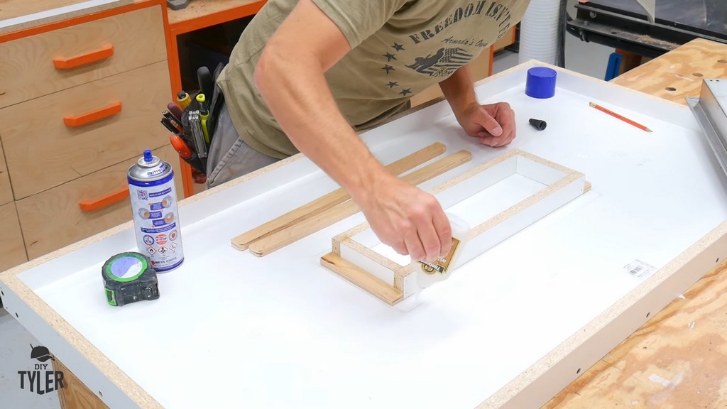 man applying glue to negative impression form for concrete mold