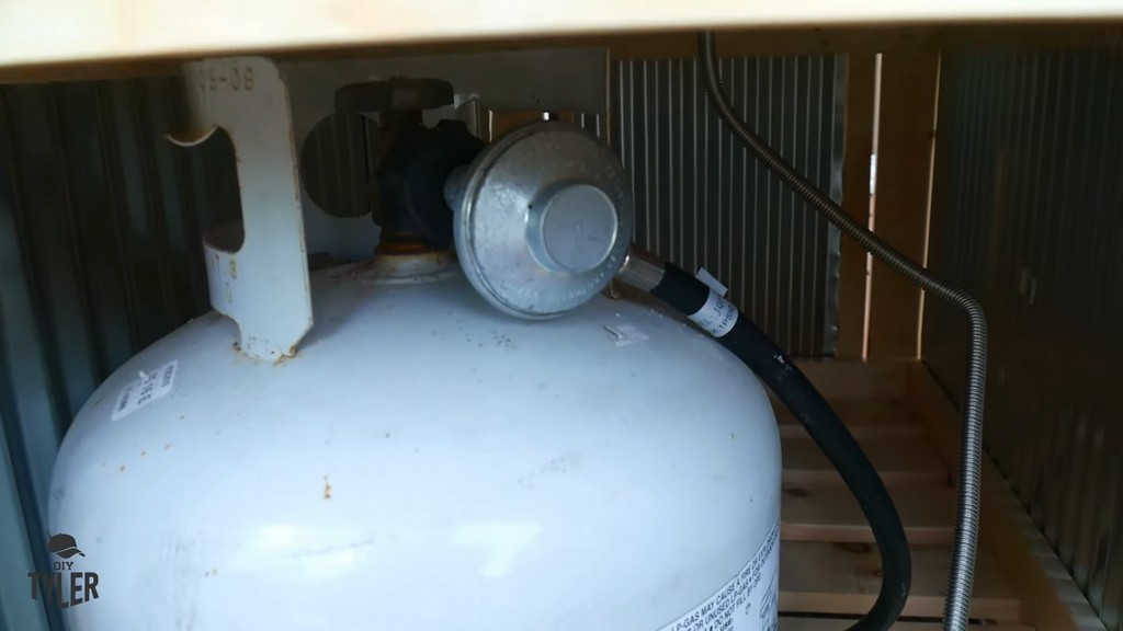 close-up of propane tank inside of DIY deck fire table frame