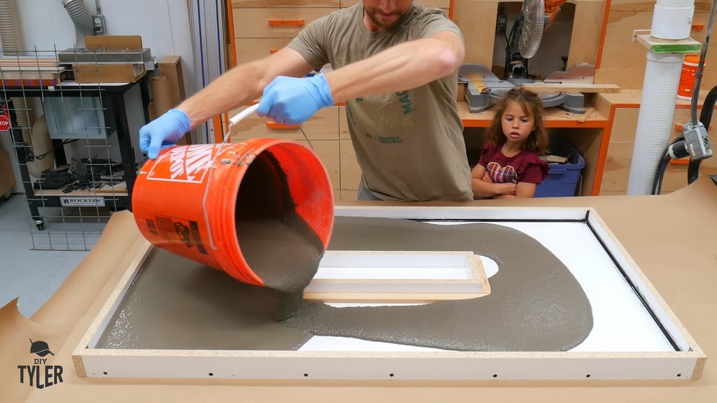 man pouring concrete mix into tabletop mold