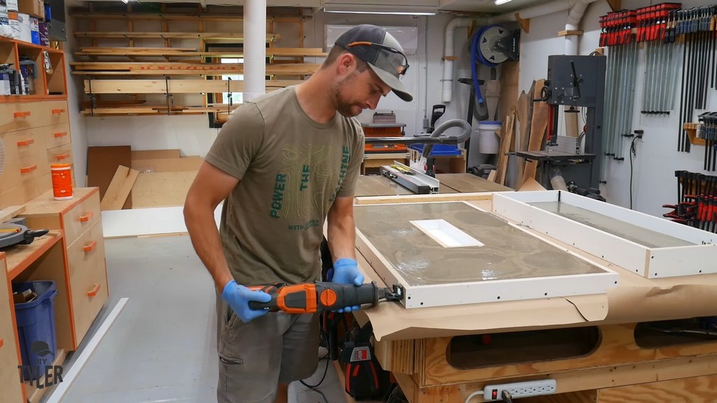 man using reciprocating saw to remove air bubbles from concrete mix