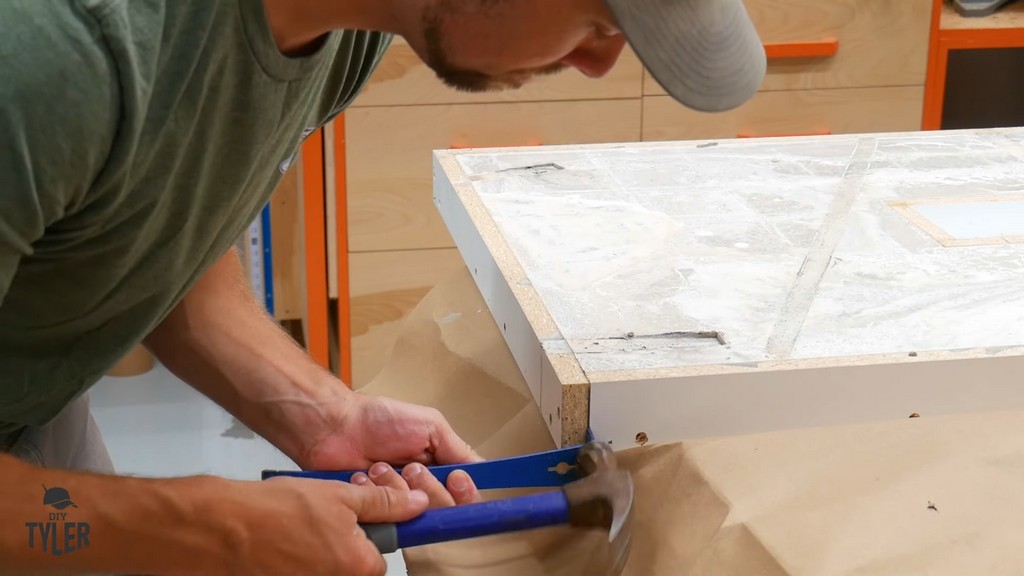 man removing melamine mold form from cured concrete tabletop slab