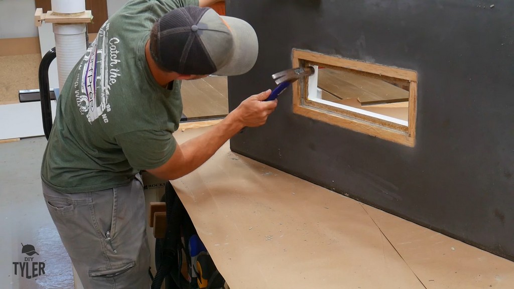 man using hammer to knock out melamine mold material from concrete slab