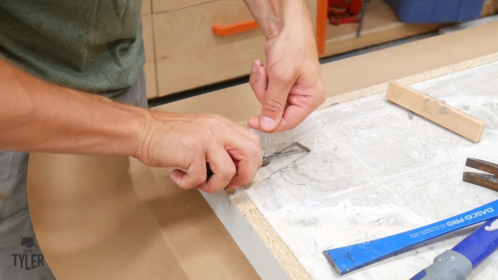 man removing scrap wood piece from cured concrete tabletop slab