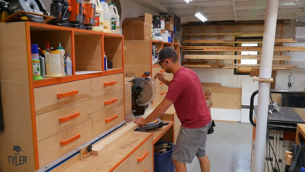 man using miter saw to cut up pieces of pine board