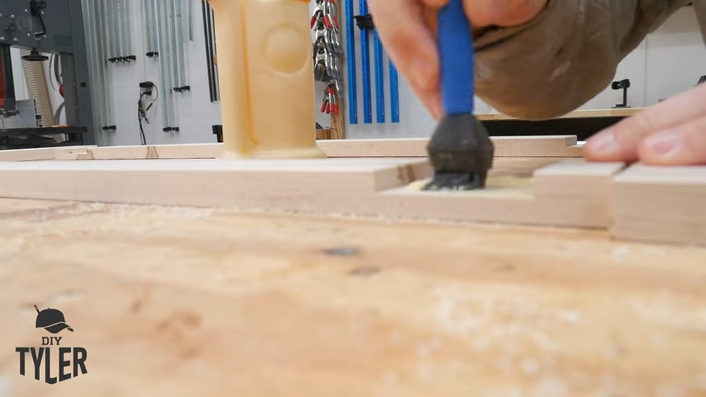 man applying wood glue to half-lap wood joint