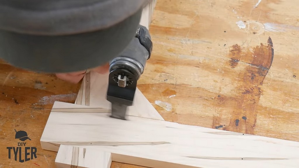 man using multitool to cut out angled piece of square picture frame
