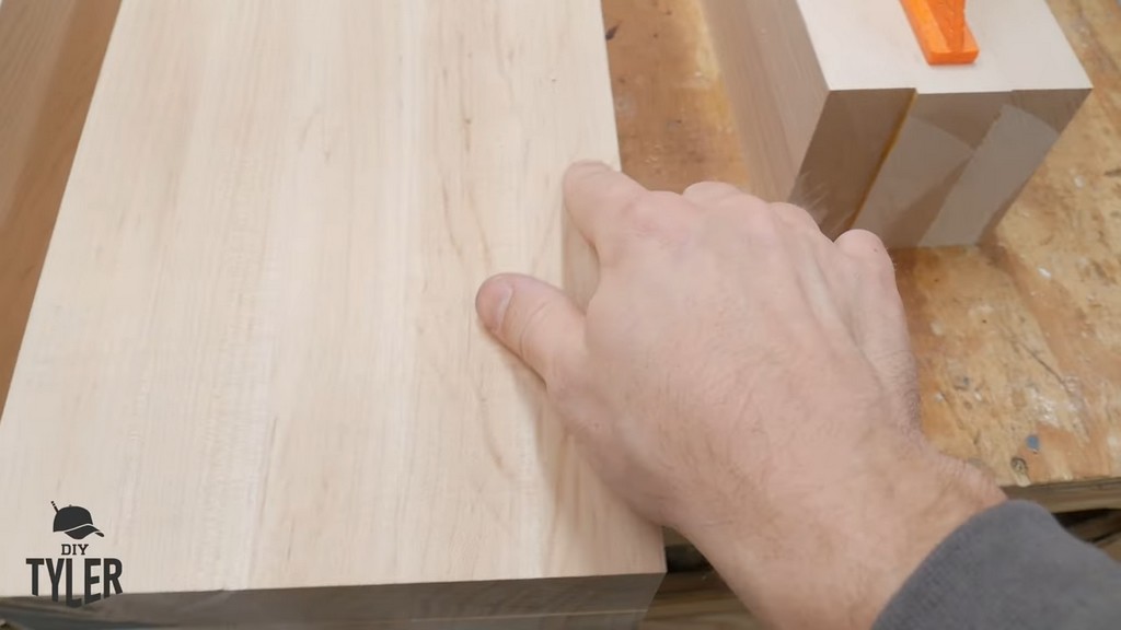 man pointing to laminated pieces of hard maple wood