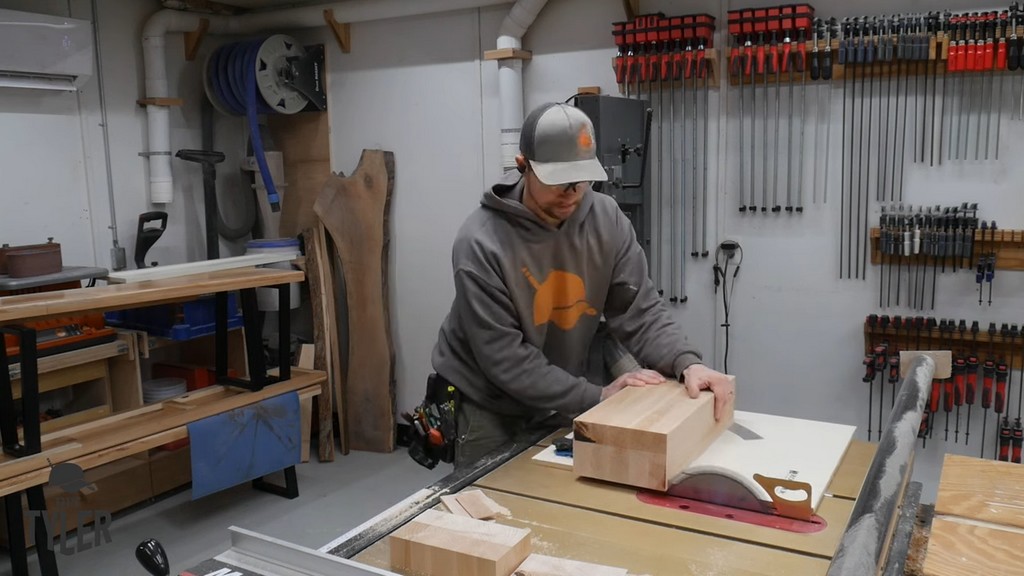 man running laminated pieces of hard maple wood through table saw